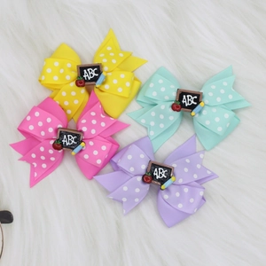 Detail of polka dot bow hair clips with ABC blackboard and pencil for school girls