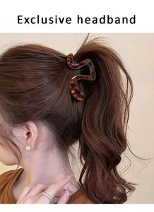 Detail of amber tortoiseshell acrylic snake hair claw securing a high ponytail for women