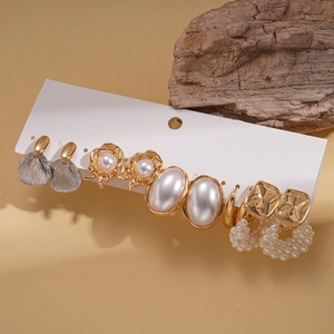 Detail of multi-style earring set with faux pearls and gold alloy on display