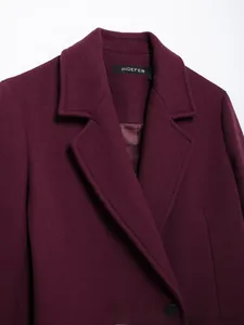 Détail d'un manteau en laine bordeaux avec larges revers et boutons noirs élégants