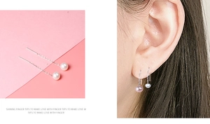 Detail of S925 silver threader earrings featuring white freshwater pearls on a model