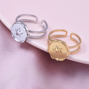 Star engraved 18k gold and silver stainless steel rings on premium silk background