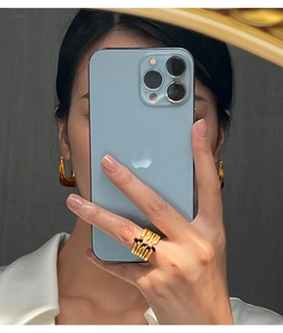 Detailed selfie showing golden layered cutout ring and geometric square-round earrings