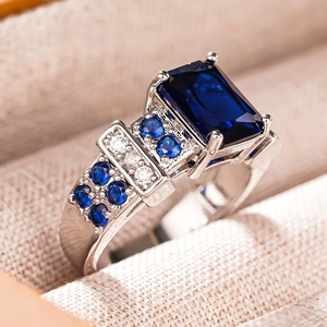 Macro shot of rectangular blue sapphire ring with sparkling diamond accents