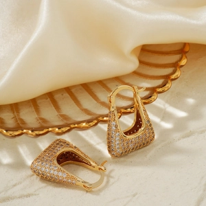 Vintage geometric trapezoid earrings in gold with pavé cubic zirconia on silk background