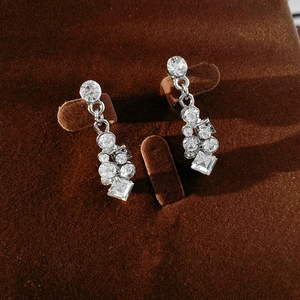 Detail of silver geometric earrings with sparkling round and square clear rhinestones