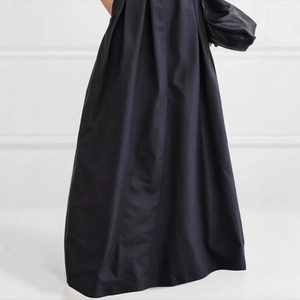 Close-up of elegant high-waisted A-line skirt featuring pleated fabric and a wide hem