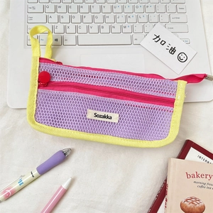 Close-up of vibrant mesh pencil case with colorful zippers on a study desk workspace