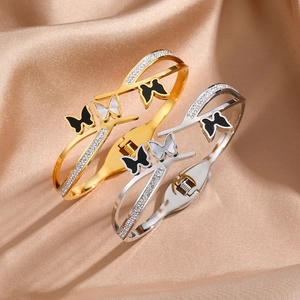 Detailed close-up of butterfly motifs on stainless steel bangles with crystal accents
