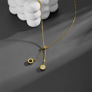 Gold titanium Roman numeral Y-necklace with black and white zircon pendant detail