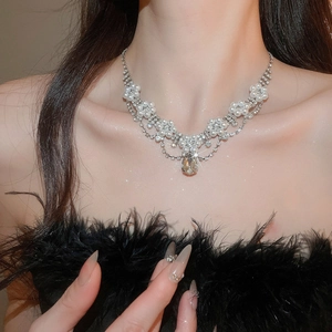Elegant pearl and rhinestone necklace set with a champagne drop pendant on a model