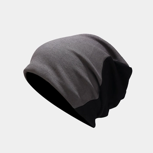 Detail of gray rib-knit and black fabric stitching on a warm autumn beanie hat