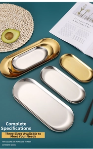 Detail of gold and silver oval stainless steel trays in small, medium, and large sizes