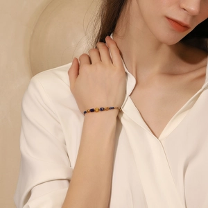 Détail d'un bracelet perlé plaqué or 18 carats avec pierres naturelles au poignet