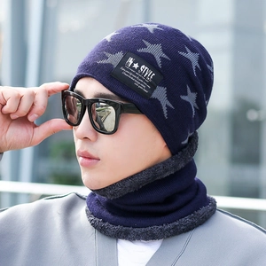 Close-up of navy blue winter knit beanie and neck warmer with grey star patterns and fleece