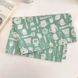 Vue détaillée de la serviette de cuisine vert menthe avec motifs d'ustensiles blancs