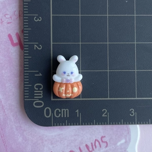 Detailed scale view of a mini white resin rabbit inside an orange pumpkin charm