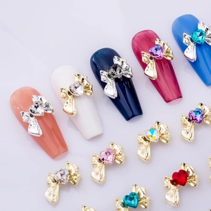 Bow nail art charms with heart crystal inlay in various colors on almond nails