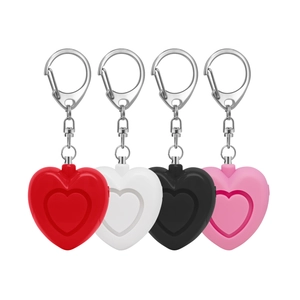 Macro view of heart-shaped personal safety alarms in red, white, black, and pink colors