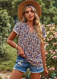 Detail of elegant V-neck floral top with white lace sleeves and colorful floral pattern