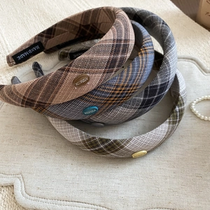 Retro padded checkered headbands in assorted colors displayed on beige linen background