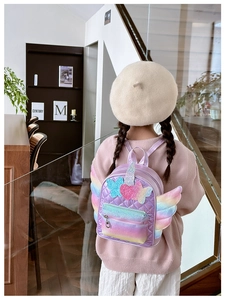 Detail of purple sequin backpack with rainbow wings and unicorn horn for kids