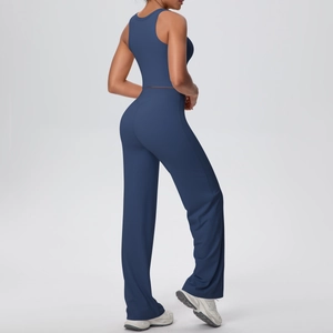 Vista laterale del set yoga blu scuro con canotta e pantaloni sportivi larghi