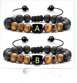 Detail of adjustable tiger eye and lava stone bracelets with gold letter charms
