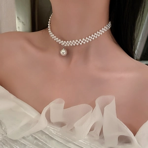 Close-up of double-layer pearl necklace with a sparkling rhinestone pendant on model