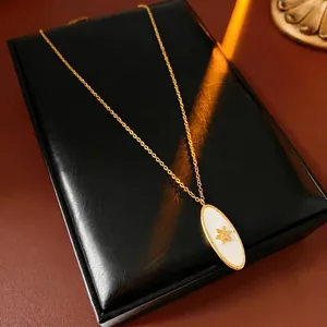 Vintage gold oval sunburst pendant necklace on black leather display case with warm lighting