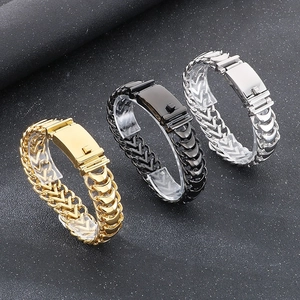 Close-up of woven dragon bone chain bracelets in gold, black, and silver steel finishes