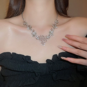 Detailed view of women's necklace featuring rhinestone-encrusted leaf and flower pendant