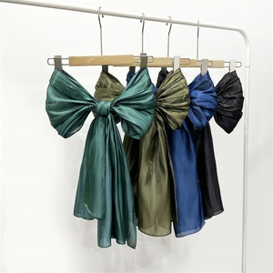 Detailed texture of semi-transparent organza bow hair ribbons in dark green and navy