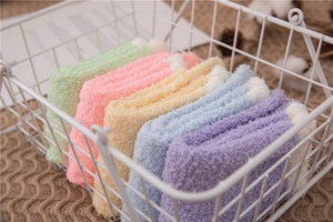 Five pairs of fluffy coral fleece thermal socks in pastel colors inside a white basket