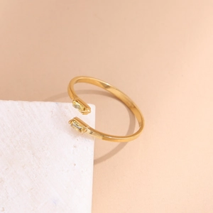 Macro shot of gold adjustable ring featuring two rectangular clear stones on a white stone