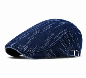 Detailed view of dark blue denim beret featuring metallic adjustable buckle and woven texture