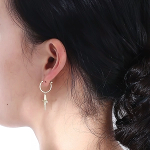 Close-up of gold cross pendant earrings with zircon stones on female model ear
