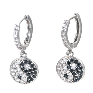 Macro view of yin yang drop earrings with micro-paved black and white cubic zirconia