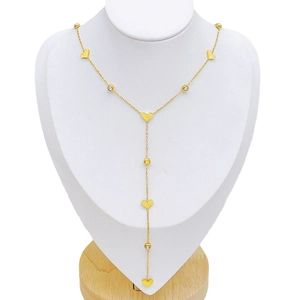 Elegant gold Y-shaped tassel necklace with heart charms and crystals on a white mannequin