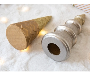 Close-up of gold and silver glitter Christmas tree toppers with warm LED lights on snow