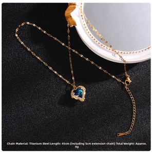 Detail of heart pendant with dark blue crystal and white cubic zirconia on gold chain