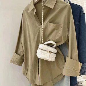 Gros plan d'un mini sac bandoulière matelassé blanc avec chaîne dorée et double zip