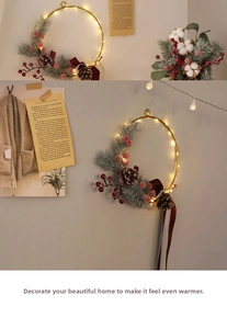 Detail of Christmas wreath with pine cones, red berries and warm LED lights on a gold ring