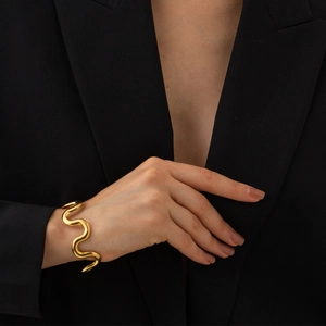 Golden wave textured titanium steel bracelet worn with a formal black blazer