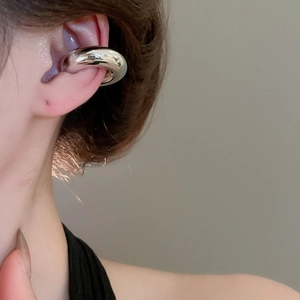 Gros plan sur l'oreille avec un ear cuff argenté poli en forme de C pour femme