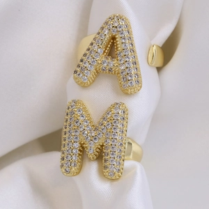 18k gold plated balloon letter rings with sparkling zircon pavé on white satin background
