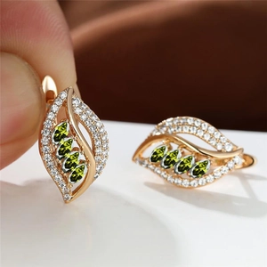 Detail of leaf-shaped champagne gold earrings with olive green marquise gems and zircons