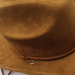 Detailed macro view of brown faux suede jazz hat texture with braided rope and metal eyelet