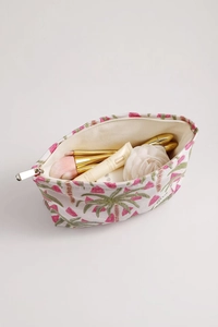 Top view of cream canvas makeup bag with jacquard palm patterns and storage space