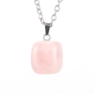 Macro detail of natural pink crystal pendant on silver link chain with subtle textures